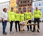 Foto: Hansestadt Stralsund/Pressestelle - Sie gehören zu den Freiwilligen, die seit September für ein Jahr in der Jugendbauhütte Stralsund arbeiten und Erfahrungen im denkmalpflegerischen Bereich sammeln (v.l.n.r. im Sweatshirt der Jugendbauhütte): Marthe Küster, Rosa Wellmann, Vittoria Guarino und Sebastian Jasper, ganz links: Petra Heldt, Geschäftsstellenleiterin des ijgd-Landesverein Mecklenburg-Vorpommern e.V. und Schleswig-Holstein e.V., ganz rechts: Christian Barth, Leiter der Jugendbauhütte Stralsund/Szczecin. Er präsentiert hier ein Produkt aus der Arbeit der Jugendbauhütte - ein sogenanntes 'Hobelpferd'.