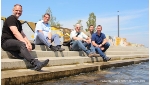 Nah am Wasser gebaut: Oberbürgermeister Alexander Badrow, Abteilungsleiter Stephan Bogusch, Planer Ulf Neubert, Künstler Robert Anderle und Carsten Müller von Rügen Recycling (v.l.n.r.) genießen das Plätschern des Strelasunds auf der Freitreppe.