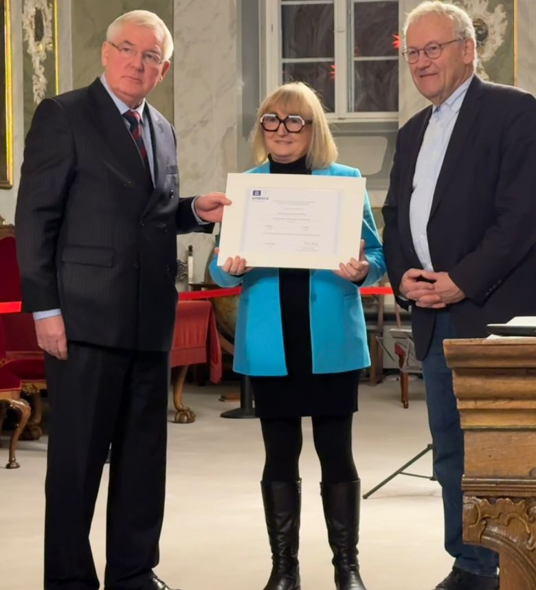 Maria Quintana Schmidt, stellvertretende Präsidentin der Bürgerschaft (Bildmitte) nimmt für die Hansestadt Stralsund die offizielle Urkunde entgegen.