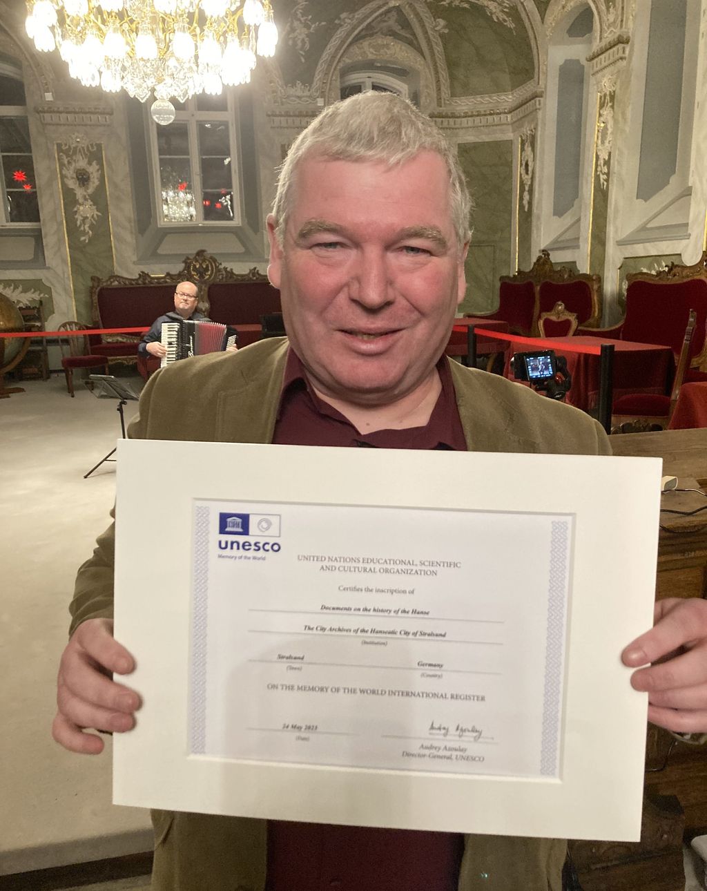 Große Freude bei dem Direktor des Stadtarchivs Stralsund, er hält die offizielle UNESCO-Urkunde in seinen Händen